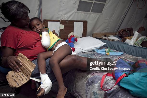 Henry Joesph and his mother, earthquake survivors, at the Red Cross medical observation tent inside General Hospital on February 8, 2010 in...