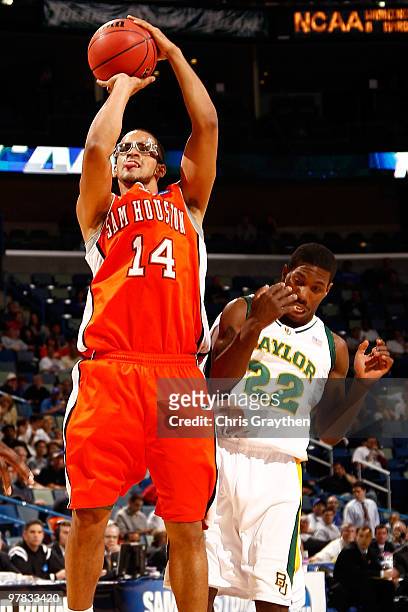 Gilberto Clavell of the Sam Houston State Bearkats shoots as he is fouled by A.J. Walton of the Baylor Bears during the first round of the 2010 NCAA...