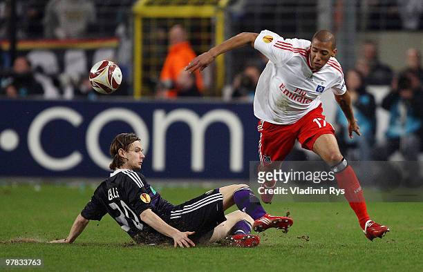 Guillaume Gillet of Anderlecht slides into Jerome Boateng of Hamburg during the UEFA Europa League round of 16 second leg match between RSC...