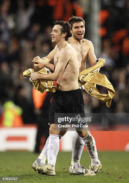 Simon Davies and Aaron Hughes of Fulham celebrate victory after the UEFA Europa League Round of 16 second leg match between Fulham and Juventus at...