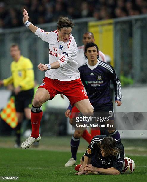 Guillaume Gillet of Anderlecht slides into Marcell Jansen of Hamburg during the UEFA Europa League round of 16 second leg match between RSC...