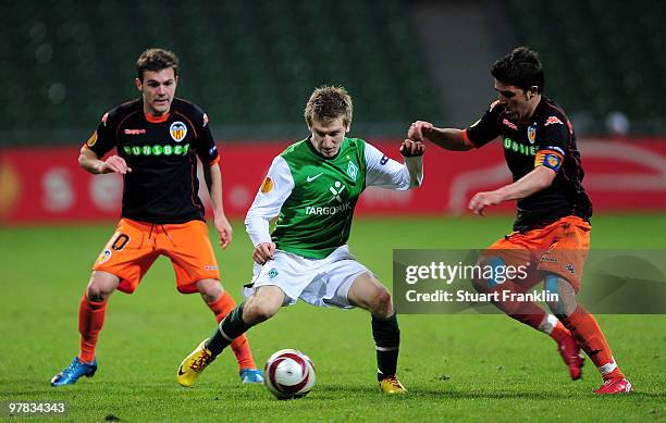 Marko Marin of Bremen is challenged by Juan Mata and Carlos Marchena of Valencia during the UEFA Europa League round of 16 second leg match between...