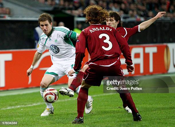 Peter Pekarik of Wolfsburg and Cristian Ansaldi and Alan Kasaev of Kazan compete for the ball during the UEFA Europa League round of 16 second leg...