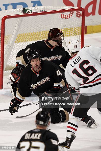 Andrew Ladd of the Chicago Blackhawks attempts a shot on goal as Aaron Ward and Jonas Hiller of the Anaheim Ducks defend in the crease during the...