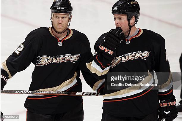 Todd Marchant and Aaron Ward of the Anaheim Ducks talk on the ice during a break in play during the game against the Chicago Blackhawks on March 17,...