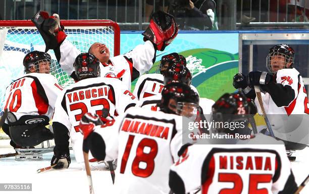 Goal keeper Mitsuru Nagase of Japan celebrates a 3-1 victory over Canada with teammates during the Ice Sledge Hockey Play-off Seminfinal Game between...