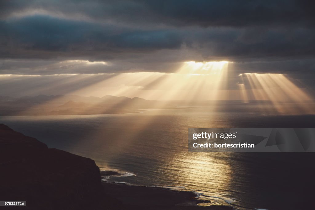 Sonnenlicht, das durch Wolken über dem Meer strömt