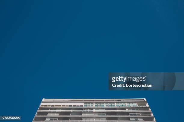 low angle view of building against blue sky - bortes photos et images de collection