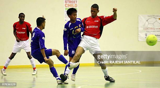Picture taken in Durban on March 15, 2010 shows street children playing football and representing their respective countries Phillipines in and the...