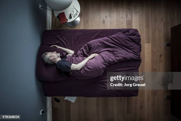 man sleeping in bed - above view of man sleeping on bed stock pictures, royalty-free photos & images