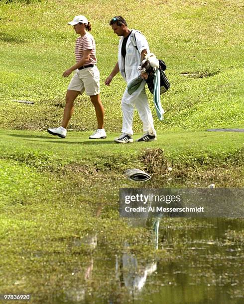 Sophie Gustafson and her caddy pass across a small stream on the 13th hole Sunday, October 12, 2003 at the Samsung World Championship in Houston,...