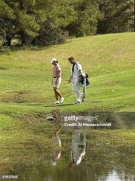 Sophie Gustafson and her caddy pass across a small stream on the 13th hole Sunday, October 12, 2003 at the Samsung World Championship in Houston,...