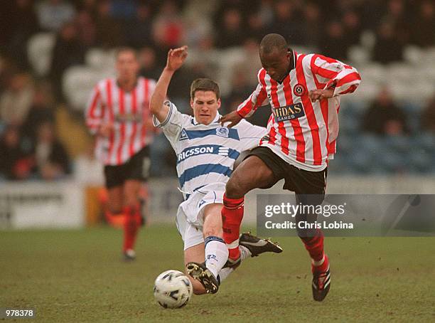 Peter Ndlovu of Sheffield United is tackled by Christer Warren of Queens Park Rangers during the Nationwide First Division match between Queens Park...
