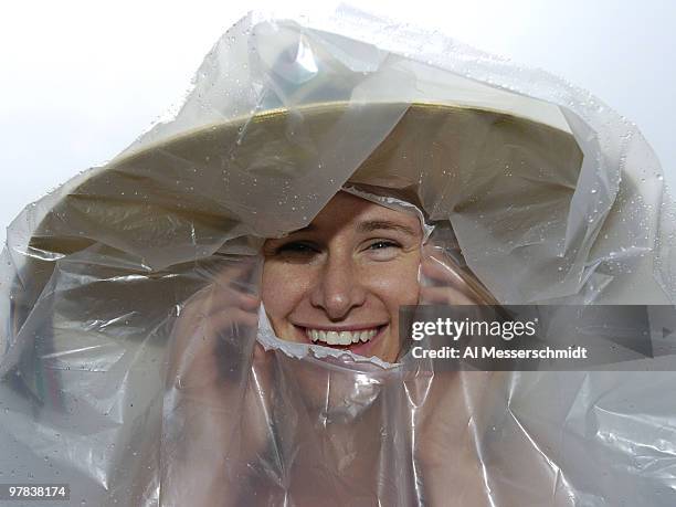 Sporty race fan protects her hat from the rain before the 130th running of the Kentucky Derby, May 1, 2004 at Churchill Downs.