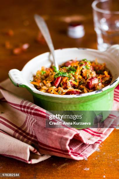 traditional polish food. bigos, stewed cabbage with carrot, onion, green lentil and pork meat sausages in a pot on a wooden table, selective focus. german cuisine. comfort food. - green lentil stock pictures, royalty-free photos & images