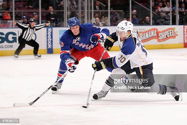 Andy McDonald of the St. Louis Blues shoots the puck in front of Marc Staal of the New York Rangers at Madison Square Garden on March 18, 2010 in New...
