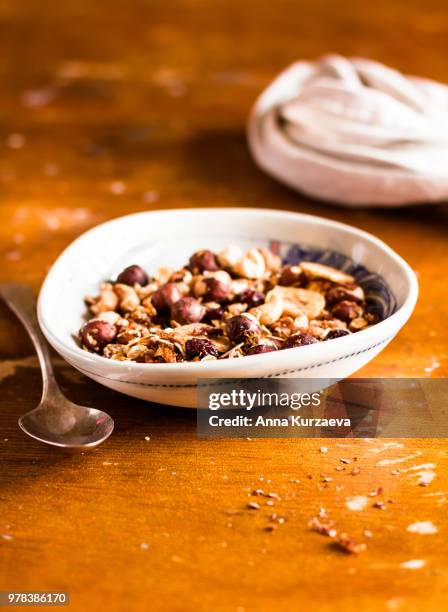 championship game of granola or muesli with toasted oat flakes, banana chips, cashew nuts, hazelnuts on a wooden table, selective focus. food for breakfast or snack. healthy and organic food. - raisin bran stock pictures, royalty-free photos & images