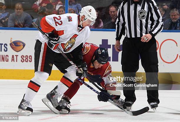 Marty Reasoner of the Atlanta Thrashers and Chris Kelly of the Ottawa Senators battle for the puck at Philips Arena on March 18, 2010 in Atlanta,...