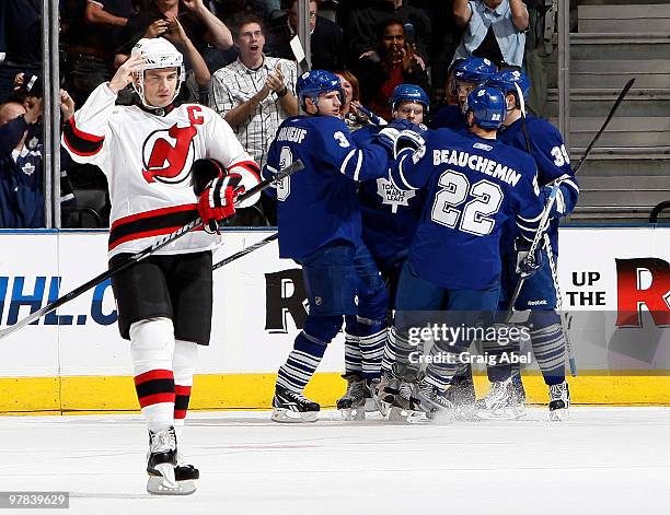 Jamie Langenbrunner of the New Jersey Devils skates past as Francois Beauchemin of the Toronto Maple Leafs celebrates a first period goal with team...