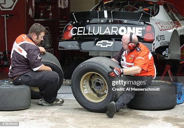 Crew workers check the tires of Joe Nemechek's car after qualifying Friday, July 9, 2004 for the NASCAR Busch Series Tropicana Twister 300 at...