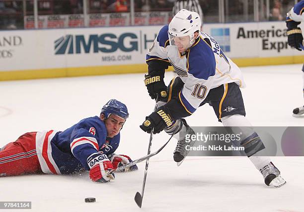 Andy McDonald of the St. Louis Blues skates the puck around Wade Redden of the New York Rangers at Madison Square Garden on March 18, 2010 in New...