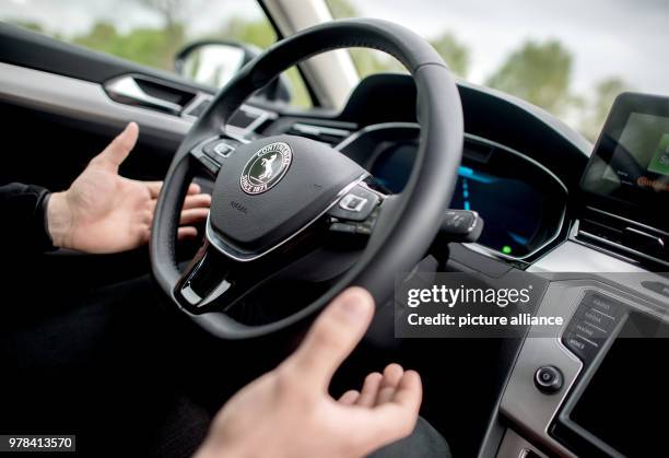 April 2018, Germany, Hanover: Test engineer Dennis Scholl drives on the A2 motorway in a "Cruising Chauffeur" car developed by Continental and lifts...