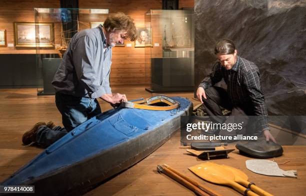 April 2018, Germany, Hamburg: The polar researcher Arved Fuchs and his crew member Tim Frank assembling a folding kayak in the Maritime Museum. The...