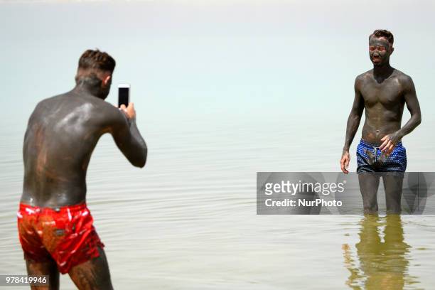 Tourist poses for a picture in the Dead Sea in Israel on June 17, 2018. The Dead Sea is a popular travel destination and lies 422 meters below sea...