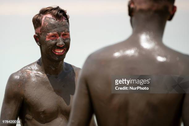 Tourists covered in mud from the Dead Sea in Israel on June 17, 2018. The Dead Sea is a popular travel destination and lies 422 meters below sea...
