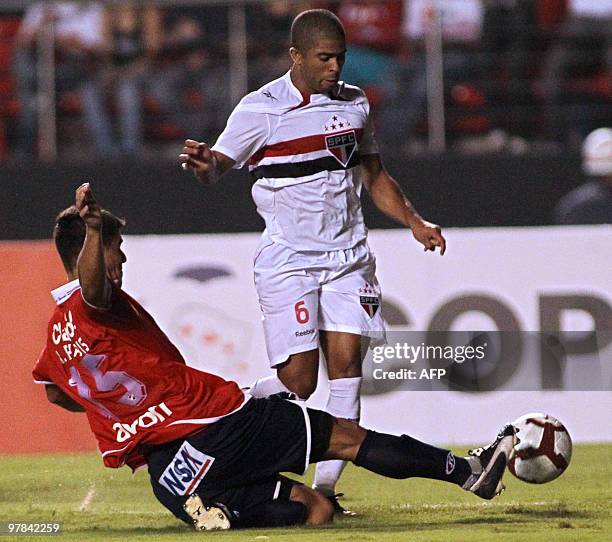 Footballer Junior Cesar , of the Brazilian team Sao Paulo, is marked by Raul Piris, of Paraguay's Nacional, during a Libertadores Cup match at the...