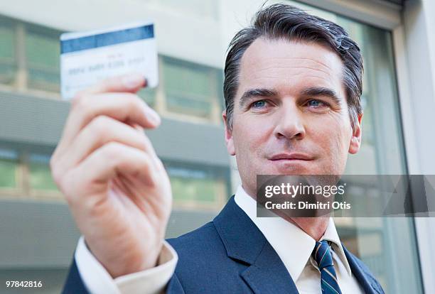 portrait of businessman holding credit card - holding above head stock pictures, royalty-free photos & images