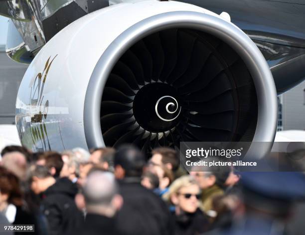 April 2018, Germany, Schoenefeld: Visiting professionals walking in front of a turbine from an Airbus A380 at the Aerospace Exhibition . Around 200...