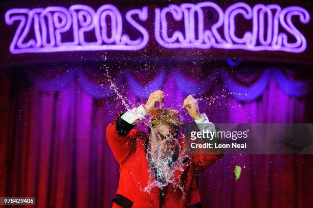 Water-filled balloon bursts over the head of clown Totti Alexis of Spain during a performance at Zippo's circus in Victoria Park on June 14, 2018 in...