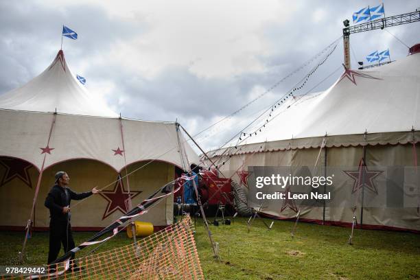 Peter Russu from Moldova secures a chain of lights following high winds at Zippo's circus in Victoria Park on June 14, 2018 in Glasgow, Scotland. As...