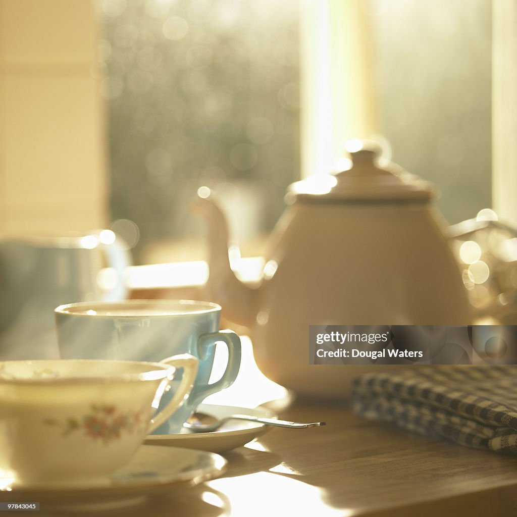 Teapot and cups in kitchen.