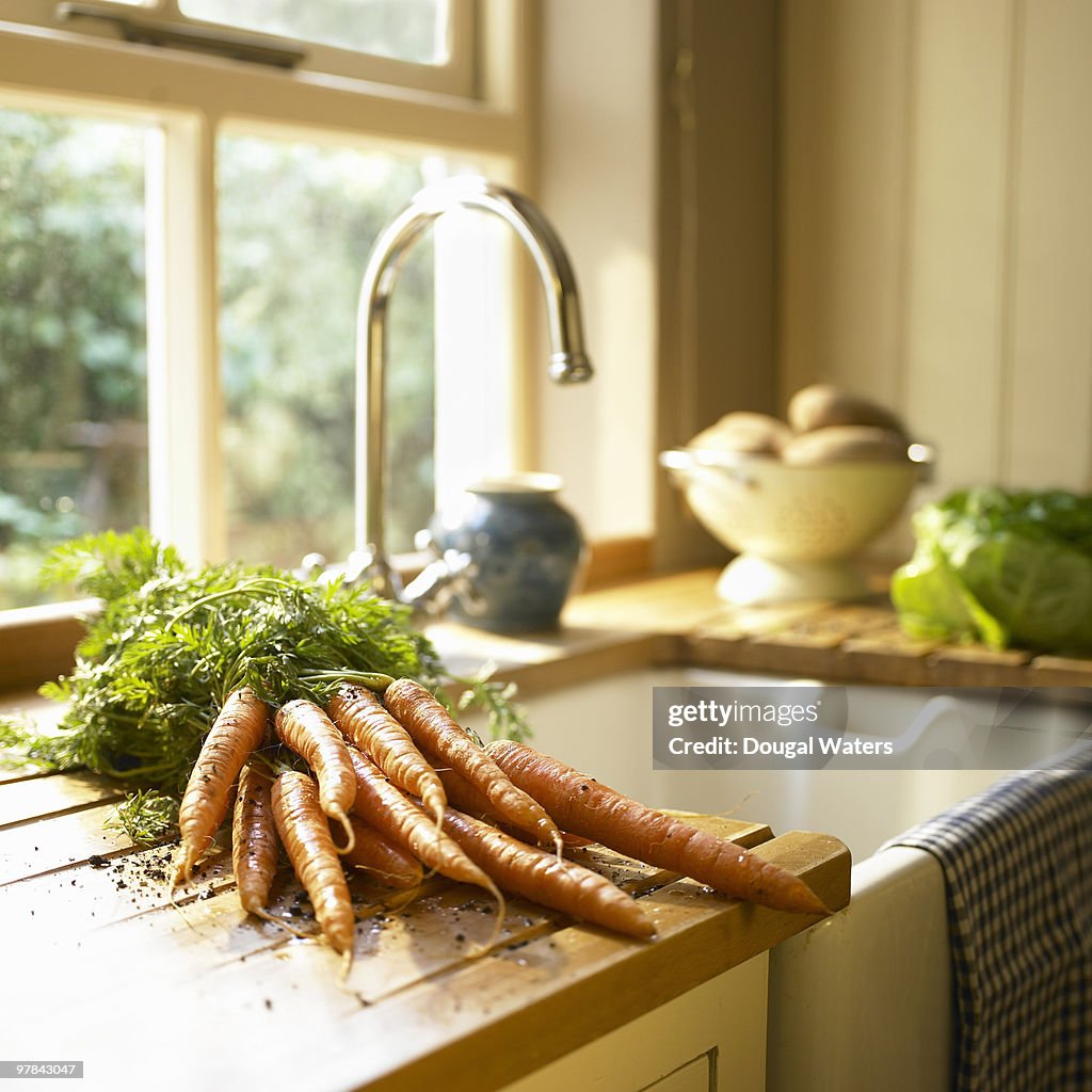 Fresh carrots on kitchen work-top.