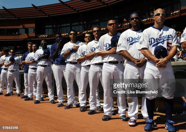 Members of the Los Angeles Dodgers stand during the National Anthem before a spring training game against the Chicago Cubs on March 18, 2010 at The...