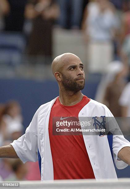 James Blake hits balls into the crowd while wearing a Carlos Beltran New York Mets jersey during his fourth round match against Tomas Berdych at the...