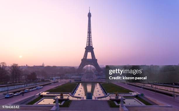 the famous eiffel tower in paris during a colorful sunrise , france - eiffel tower sunrise photos et images de collection