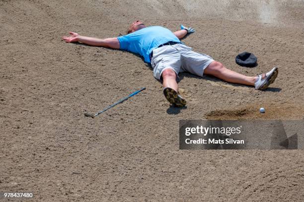 desperate golfer lying in a bunker - golf bunker fotografías e imágenes de stock