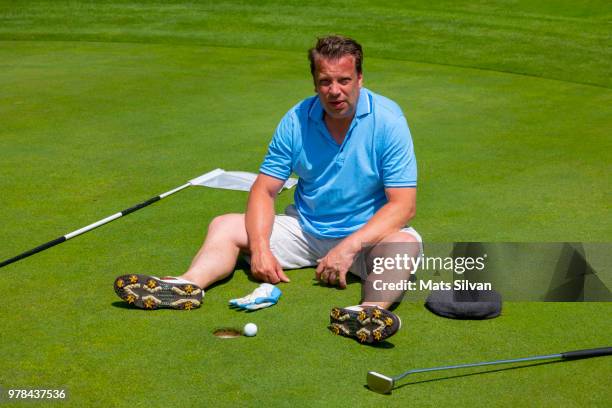 disappointed golfer sitting on a golf green - breitbeinig stock-fotos und bilder