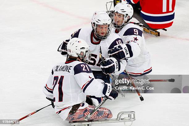 Taylor Chace of the United States celebrates his goal during second period with teammates Alexi Salamone and Andy Yohe during the Ice Sledge Hockey...