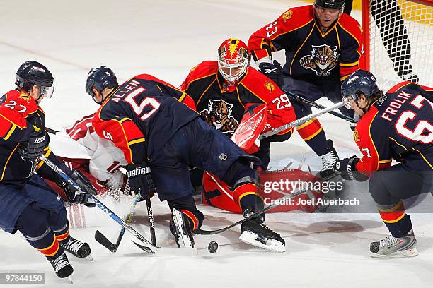 Petr Prucha of the Phoenix Coyotes has his shot stopped by Goaltender Tomas Vokoun of the Florida Panthers as he is checked by Bryan Allen on March...