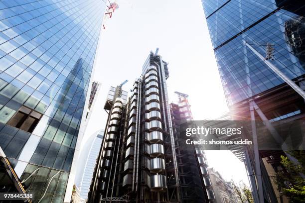 looking up at futuristic london skyscrapers against sky - lloyds of london stock-fotos und bilder