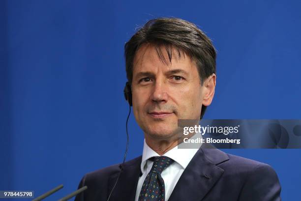 Giuseppe Conte, Italy's prime minister, wears an earpiece during a news conference with Angela Merkel, Germany's chancellor, at the Chancellery in...