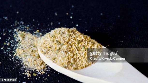 mixed spices in wooden spoon on black background. - oregano ストックフォトと画像