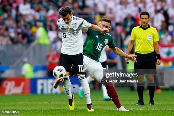 Mesut Ozil of Alemania and Hector Herrera of Mexico fight for the ball during the 2018 FIFA World Cup Russia group F match between Germany and Mexico...