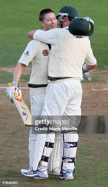 Michael Clarke of Australia celebrates scoring a century with team mate Marcus North during day one of the First Test match between New Zealand and...