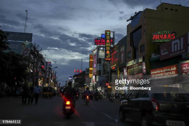 Vehicles travel past stores illuminated at dusk in Coimbatore, Tamil Nadu, India, on Friday, June 8, 2018. Most Asian markets were in the red on June...