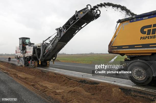 April 2018, Germany, Tribsees: Milling machine at work on the partly sunken baltic sea A20 motorway. 800 metres will be dismantled in total in order...